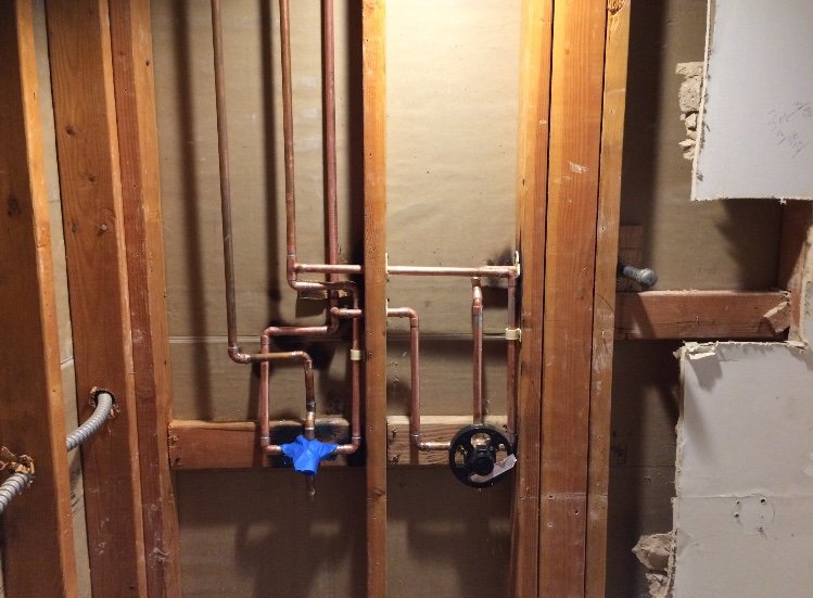 behind shower wall plumbing lines and valves